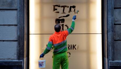 Un treballador municipal esborrant una pintada d'ETA.
