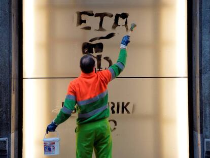 Un treballador municipal esborrant una pintada d'ETA.