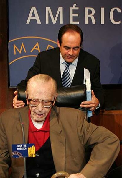 El ministro Bono ayuda a sentarse al teólogo Díez-Alegría.