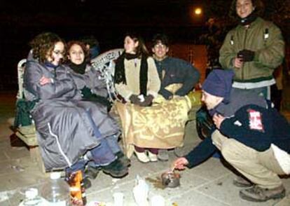 Estudiantes compostelanos preparan una <i>queimada</i> a la intemperie en la noche del jueves.