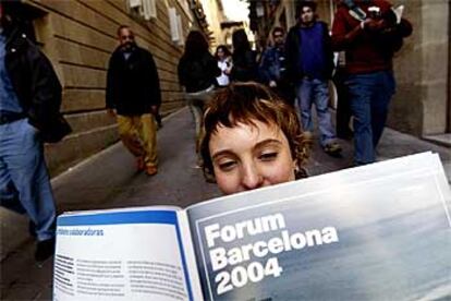 En la calle del Bisbe, en el barrio Gótico de Barcelona, una joven consulta la guía del Fòrum Barcelona 2004, que recoge la programación dentro y fuera del recinto entre el 9 de mayo y el 26 de septiembre.