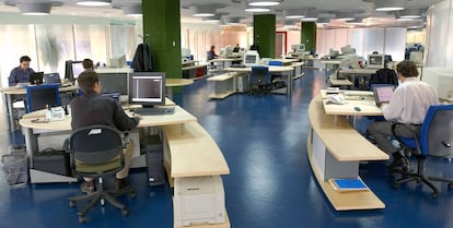 Empleados trabajando con ordenadores en una oficina.