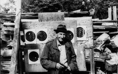 El escritor William S. Burroughs, fotografiado con una pistola y unas dianas de tiro al blanco.