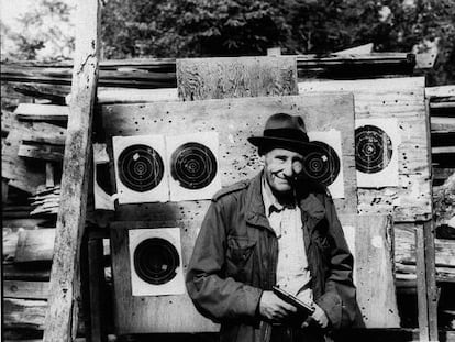 El escritor William S. Burroughs, fotografiado con una pistola y unas dianas de tiro al blanco.
