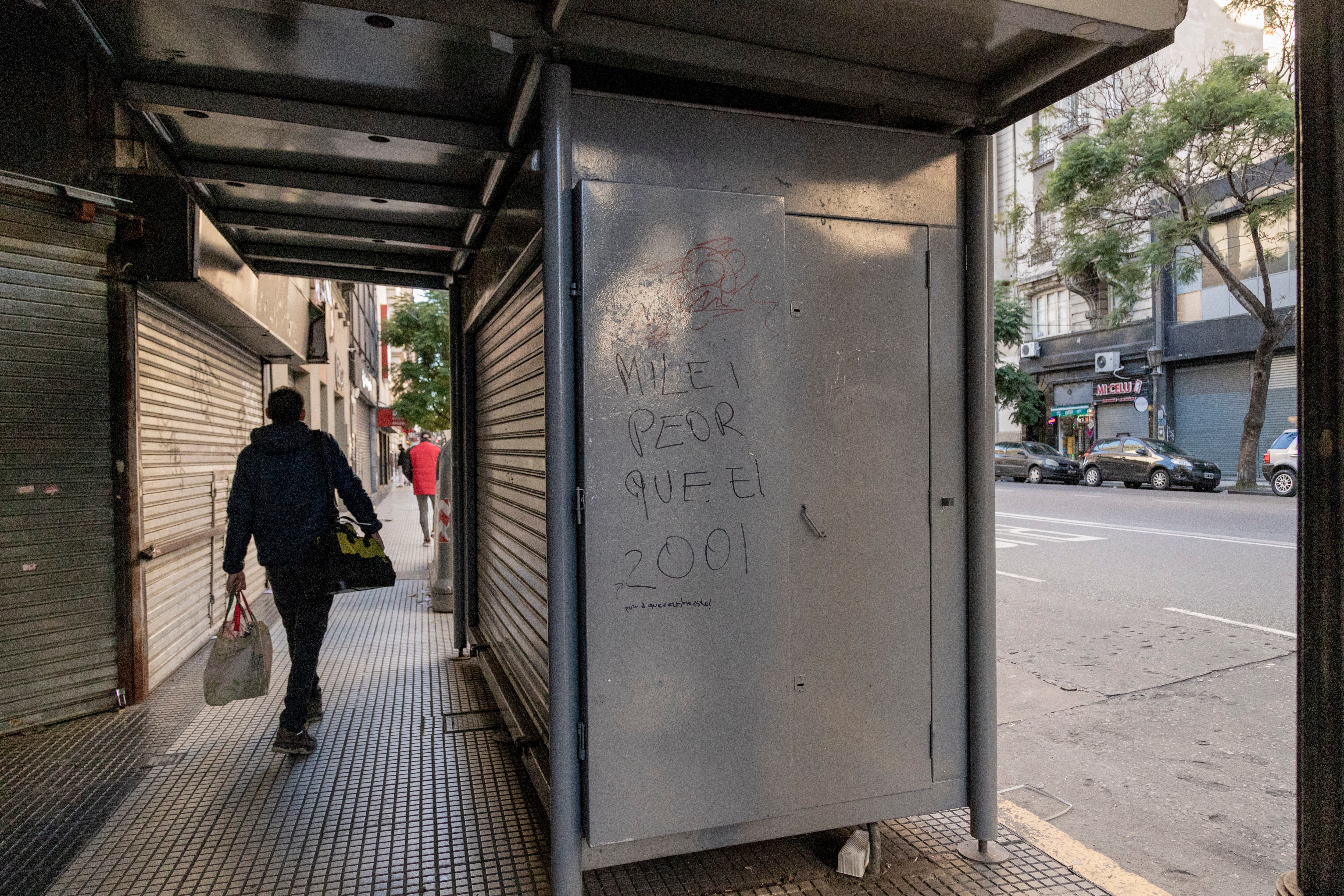 Un grafiti contra Milei en la avenida Callao, vialidad casi vacía.