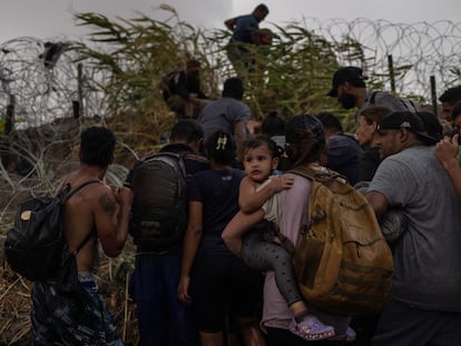 Un grupo de migrantes cruzan el río Bravo desde México en Eagle Pass, Texas.