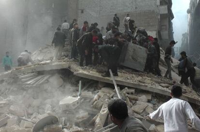 Un grupo de sirios buscan a supervivientes de un edificio derrumbado en la ciudad de Alepo después de la explosión de una bomba.