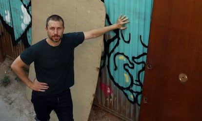 Carlos Garc&iacute;a frente al muro tras el que se encuentra el solar en el que se encontraba su casa que le expropiaron y derribaron hace cuatro a&ntilde;os en Lavapi&eacute;s  
 