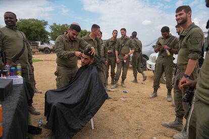 Soldados israelíes, desplegados cerca de la frontera con Gaza, se rapan el pelo este lunes. 