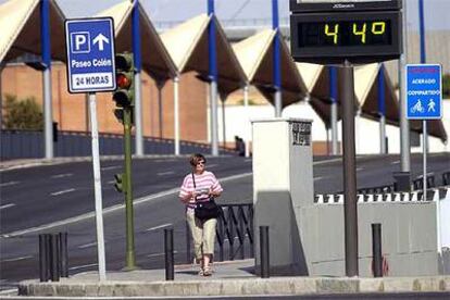 Una turista pasea por el puente del Cristo de la Expiración de la ciudad de Sevilla con 44 grados.