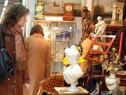 Una mujer mira los objetos de uno de los puestos de la Fira de Brocanters.