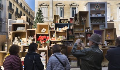 Varias personas fotografían el belén de plaza Sant Jaume de Barcelona.