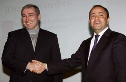 Khodorkovsky (izquierda) estrecha la mano de Shvidler tras anunciar el acuerdo de las petroleras.