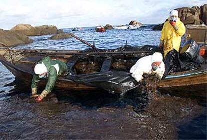 Marineros de Santa Mariña (A Coruña) recogen con las manos el chapapote vertido por el <b></b><i>Prestige.</i>