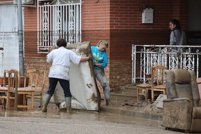 Dos mujeres sacan un colchón de una vivienda afectada por las inundaciones en la localidad toledana de Cobeja.  