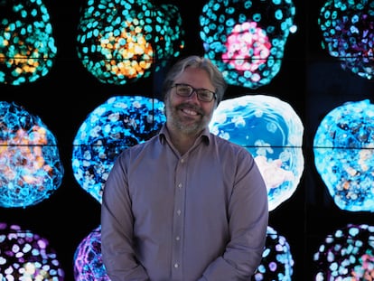 Biochemist José Polo poses with images of his human pseudo-embryos.