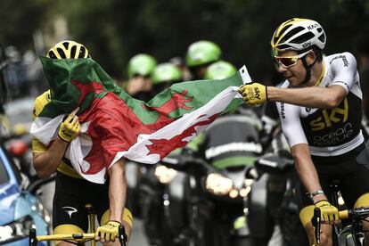 Geraint Thomas, vestido con el maillto amarillo junto a su compañero de equipo Luke Rowe, sostienen la bandera de Gales durante la etapa 21º del Tour de Francia.