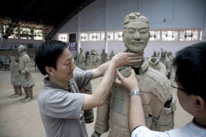 Arqueólogos chinos en los trabajos de restauración de los famosos guerreros de Terracota, en la excavación arqueológica cuyos trabajos continúan, en la ciudad de Xian, China, hoy, martes 3 de julio. Seis mil de estas estatuas de dos mil años de antigüedad, que rodeaban la tumba del primer emperador chino, han sido desenterradas y reparadas y quedan miles más bajo tierra esperando su turno. Unos campesinos chinos encontraron las piezas de los soldados de barro en 1974 cuando cavaban un pozo cerca de la tumba de Qin Shi Huan, el primer emperador de China.