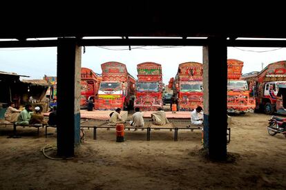 Un grupo de conductores descansa en unas camas frente a sus camiones en Faiasalabad (Pakistán).