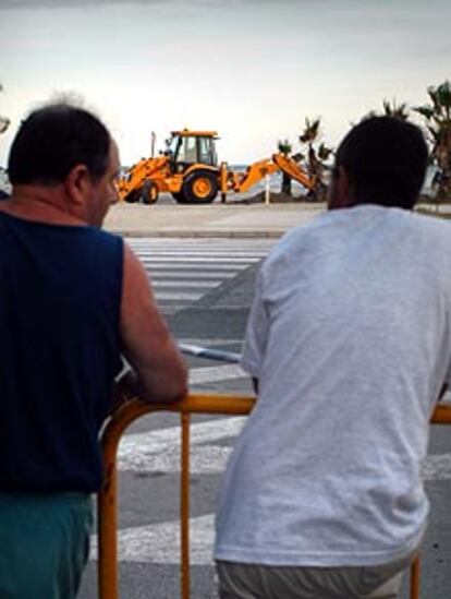 Unos bañistas observan la búsqueda de la bomba en la playa de Santa Pola.