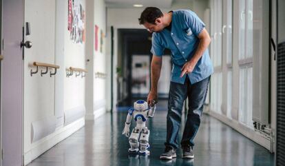 Mickaël Feret, uno de los enfermeros de Jouarre, camina con el robot por el hospital.