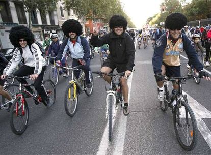 Cuatro ciclistas ataviados con pelucas participan en el 'día de la bicicleta'.