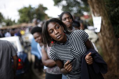 Una mujer observa la llegada del primer ministro y candidato a la presidencia de Kenia, Raila Odinga, en un colegio electoral de Nairobi.