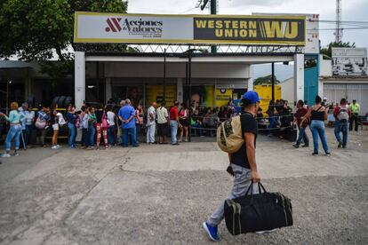 Ciudadanos hacen fila en una casa de cambio para recoger el dinero que les envían sus familias desde el extranjero.
