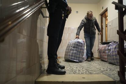 El Yagoubi, que trabaja como vigilante nocturno, saca pertenencias de la vivienda de la que ha sido desahuciado en presencia de un agente de policía.