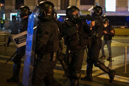 Un agente de los Mossos d'Esquadra apunta con la pistola durante las protestas en Barcelona.