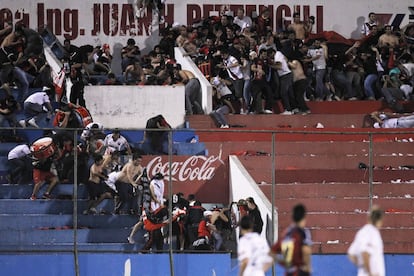 Los seguidores del Colón se resguardan de las pelotas de goma disparadas por los policías.