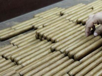 Un trabajador cubano de Partag&aacute;s elabora cigarros premium.