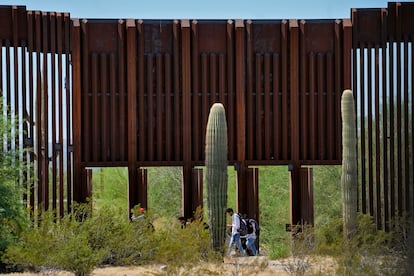 A group of migrants crosses through a gap in the wall in the middle of the desert between Sonora and Arizona, in August of this year.