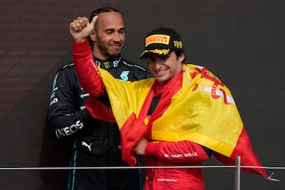 El piloto español de Ferrari, Carlos Sainz, celebra su victoria en el Gran Premio de Gran Bretaña de Fórmula Uno mientras el piloto británico de Mercedes, Lewis Hamilton, mira hacia atrás, en el circuito de Silverstone