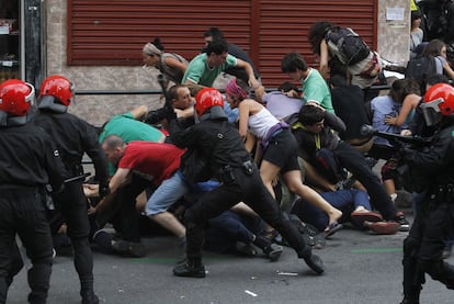 Agentes de la Ertzaintza cargan contra manifestantes junto al local okupa desalojado en Bilbao.