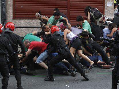Agentes de la Ertzaintza cargan contra manifestantes junto al local okupa desalojado en Bilbao.