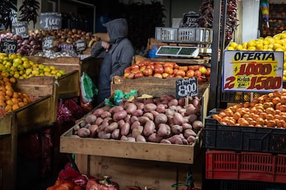 Un hombre atiende su local de verduras en la Vega Central.