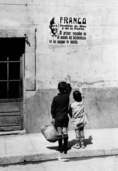 Septiembre. Dos niños saludan brazo en alto ante uno de los carteles con la efigie de Franco colocados al terminar de la Guerra Civil.