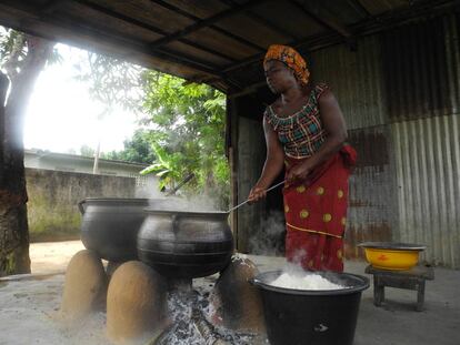 Una mujer cocina en cacerolas en el centro escolar de N'Zikro, en Costa de Marfil.