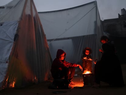 Refugiados palestinos se calientan al fuego en Rafah, al sur de la Franja de Gaza.