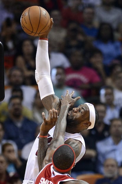 LeBron James recibe un manotazo de Josh Smith.