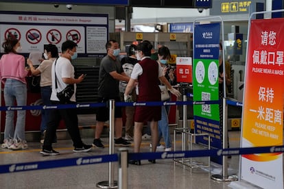 An airliner worker asks traveller to declare their health information after checking in at the international flight check in counter at the Beijing Capital International Airport in Beijing, Aug. 24, 2022.