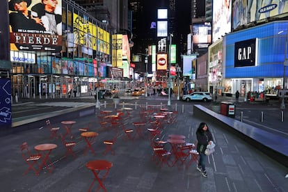 Mulher trafega em uma Times Square quase vazia, em Nova York, na noite de segunda.
