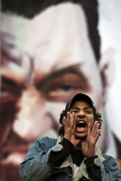 Un manifestante, ante una imagen de Mubarak en El Cairo.