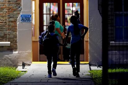 A pesar de que las clases comenzaron hace semanas en muchas partes de Texas, las autoridades optaron por retrasar el primer día de clases en Uvalde ante la angustia de sus habitantes y las fallas en el sistema de orden público. En la imagen, dos alumnos se toman de la mano durante su ingreso en la escuela primaria Uvalde.