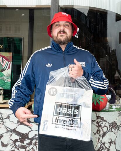 Un seguidor de Oasis muestra orgulloso sus compras.