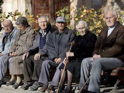 Un grupo de pensionistas sentados en un banco.
