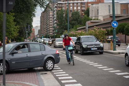 Una mujer con una de las bicis del servicio municipal de préstamo esquiva un coche en el ciclocarril de la avenida Isabel la Católica, en Valladolid.
