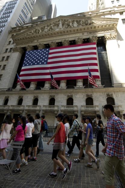 Un grupo de turistas pasa ante la Bolsa de Nueva York.