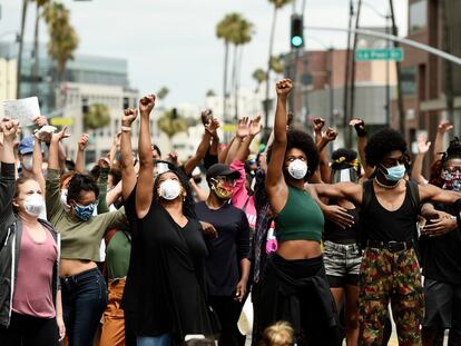 Manfiestantes del movimiento Black Lives Matter alzan el puño en Beverly Hills, California.